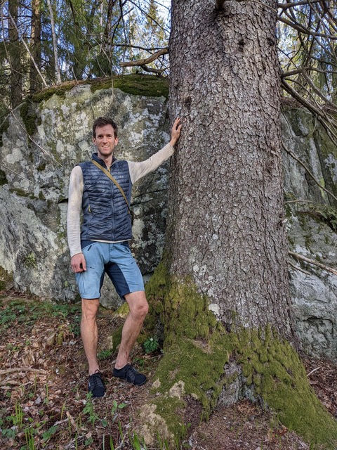 Eirik Johansen Dobbedal, som lenser seg mot et stort tre.
